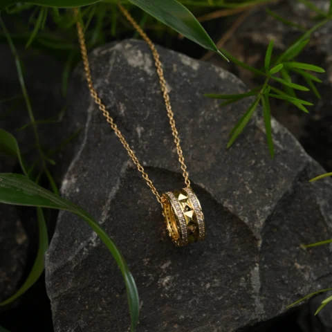 Gold Dual-Ring Pendant with Pyramid Studs and Crystal Borders