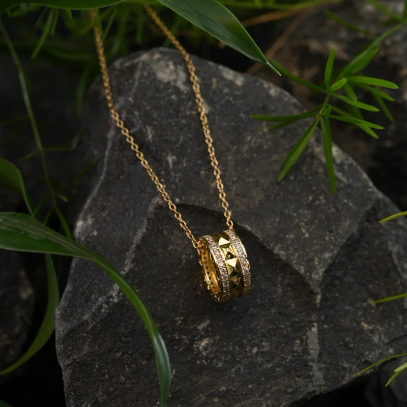 Gold Dual-Ring Pendant with Pyramid Studs and Crystal Borders